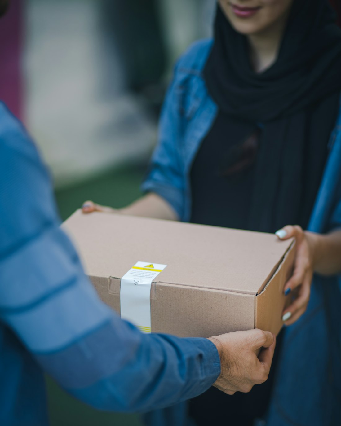Un colis remis en main propre a une cliente, a l'arrivee